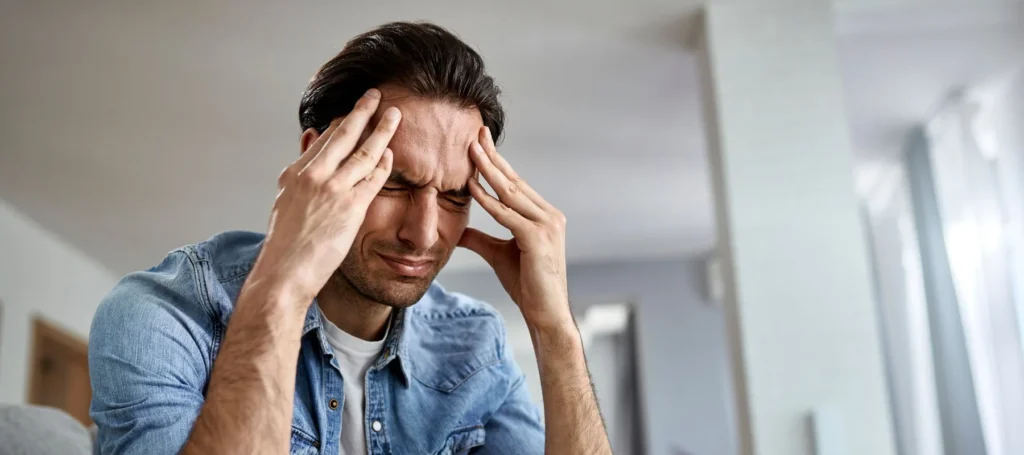 man holding head because of headache