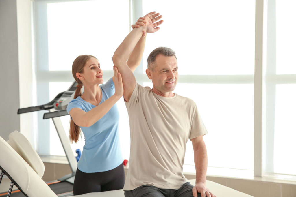 Physiotherapist working with mature patient in rehabilitation ce